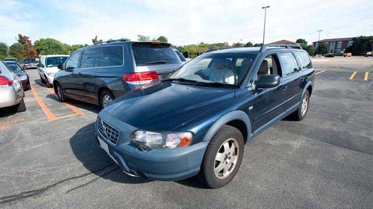 Person driving slow in a parking lot to prevent a car accident.